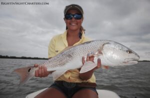 mosquito lagoon redfish caugh on fly being held by a client